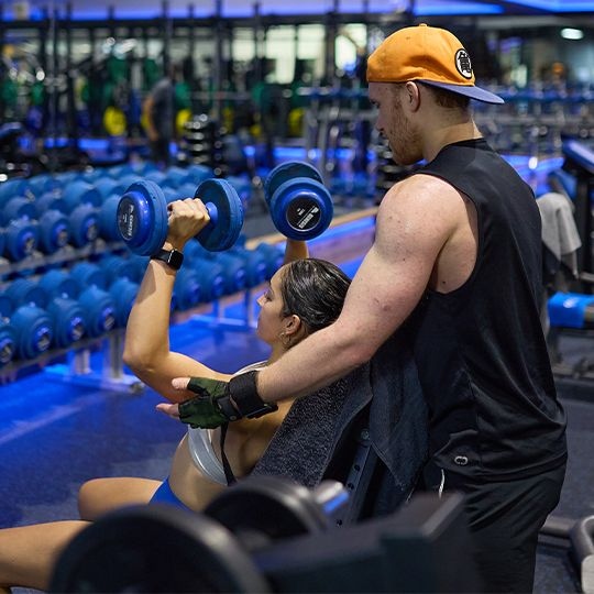 People doing shoulder press with free weights together